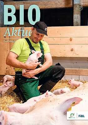 Titelseite Bioaktuell, ein Mann mit einem Ferkel im Arm, umringt von weiteren Ferkeln