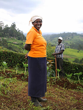 A woman and a man standing in a field in the background