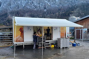 Geöffneter Anhänger auf einem Hofplatz.
