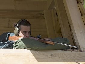 Nils Müller dans la cabine de tir avec un fusil.