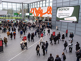 Viele Besucherinnen und Besucher in einer großen Messehalle.