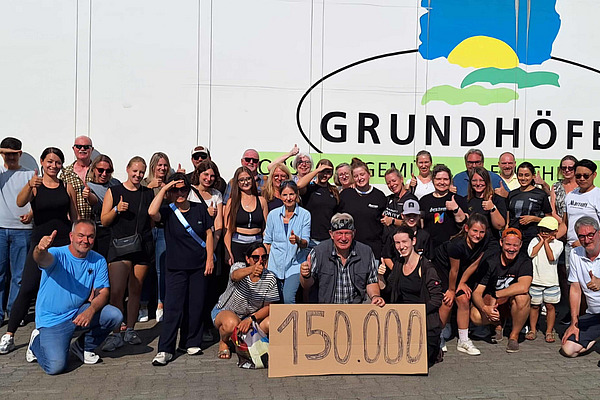 Menschengruppe mit einem Schild, auf dem 150.000 steht. 
