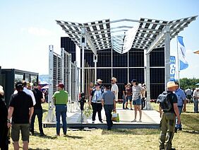 Menschen sehen sich eine Photovoltaik-Anlage an 