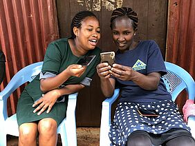 Women farmers from East Africa read a text message