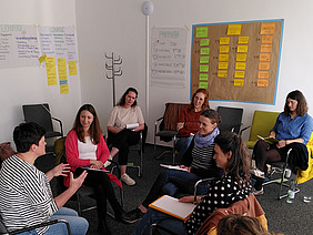 Mehrere Menschen in einer Seminarsituation