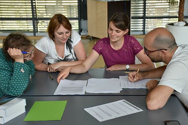 Mehrere Personen studieren Papiere.