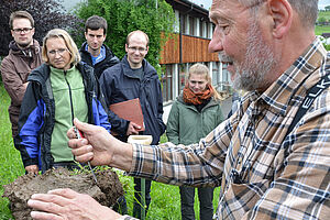 Diverses personnes regardent un homme au test de beche