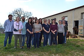 Photo de groupe avec 15 personnes, à droite au fond 4 chèvres