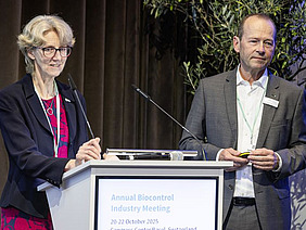 Eine Frau und an Mann an einem Podest.