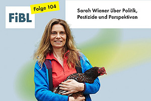 Eine Frau mit einem Huhn auf dem Arm.