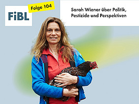 Eine Frau mit einem Huhn auf dem Arm.