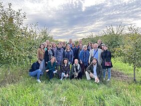 A group of people in a field with trees