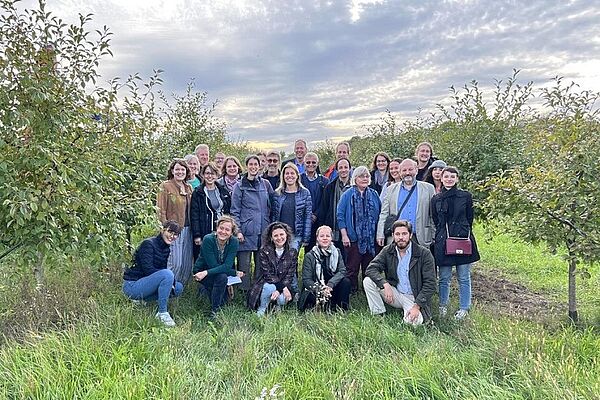 A group of people in a field with trees