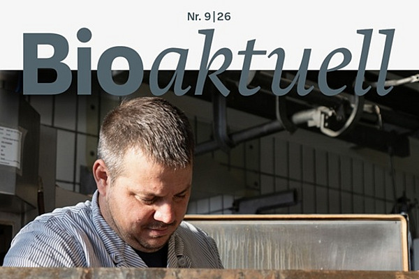 Titelseite Bioaktuell 9|26: Ein Mann legt Fleischstreifen auf ein Gitter.