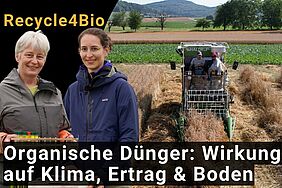Zwei Frauen im Vordergrund, ein Mähdrescher im Hintergrund.