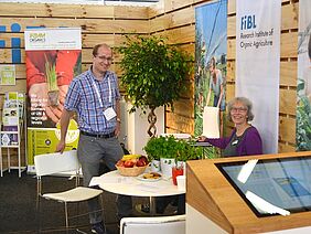 Two people standing at an information booth