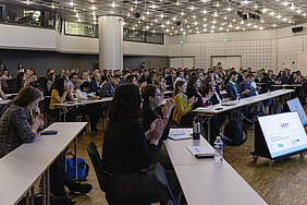 A room with people sitting at tables.