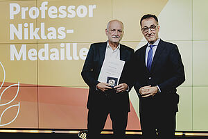 Zwei Männer mit Medaille.