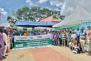 A group photo arranged in a U-shape, with people in the centre holding a banner.