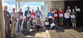 People in a conference room gathering around a banner.